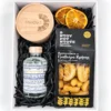 The Cretan Treat Box Συνθεση δωρου σε λευκο κουτι με τσικουδια Athivoli, κριτσινακια με γραβιερα Κρητης ΝτουρουΝτους, προσωποποιημένο κερί σόγιας σε βάζο με χαραγμένο λογότυπο στο καπάκι και αποξηραμενες φετες πορτοκαλι